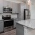 a kitchen with white cabinets and easy access to the living area