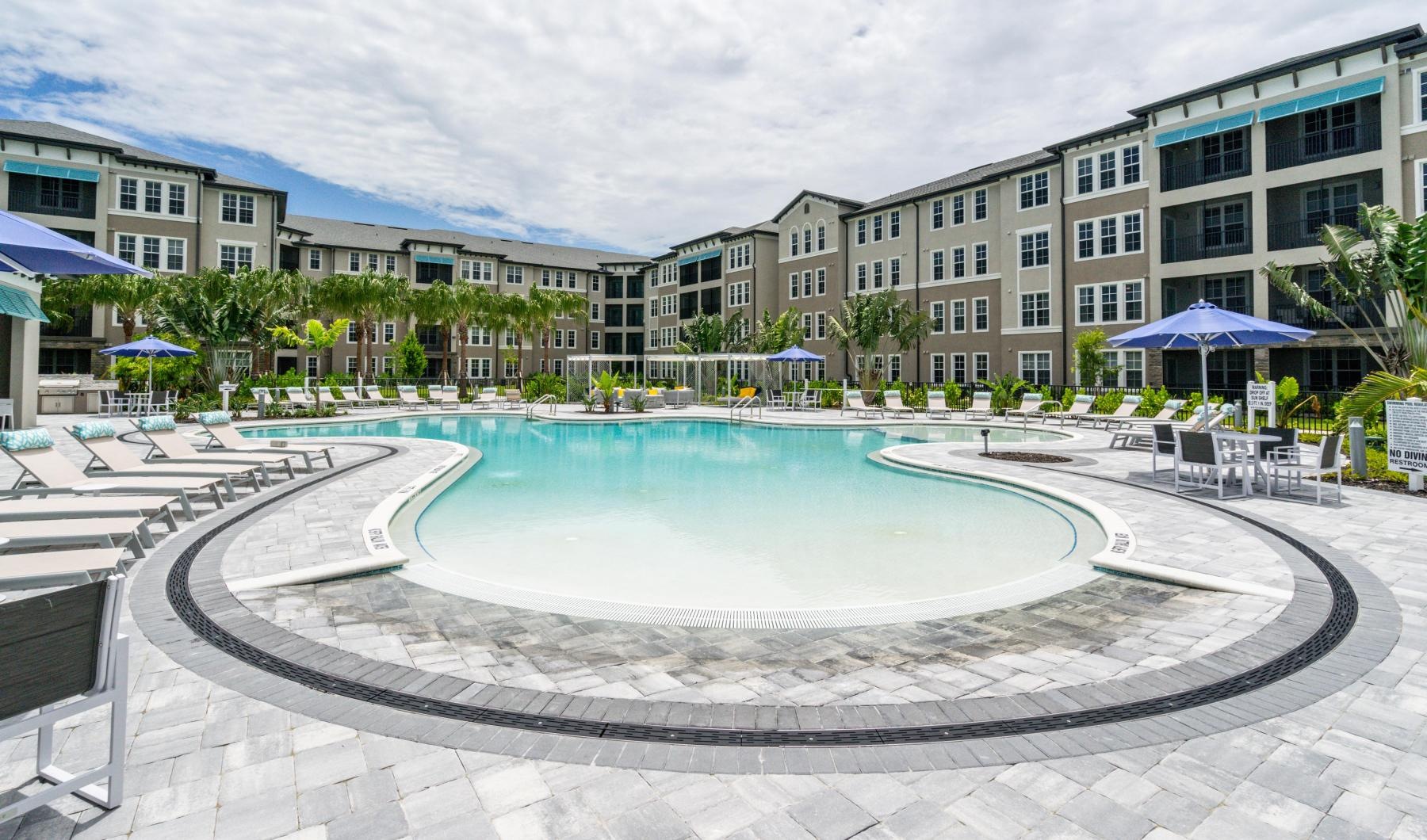 a pool in a courtyard with buildings in the background